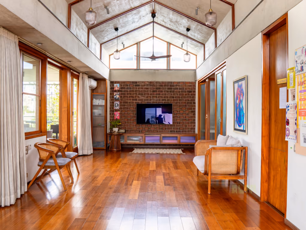 The main hall, looking towards a brick wall under a high gabled ceiling hung with glass pendants